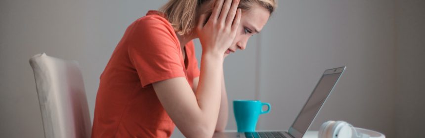 Kvinna tittar på datorn och är orolig över boräntan